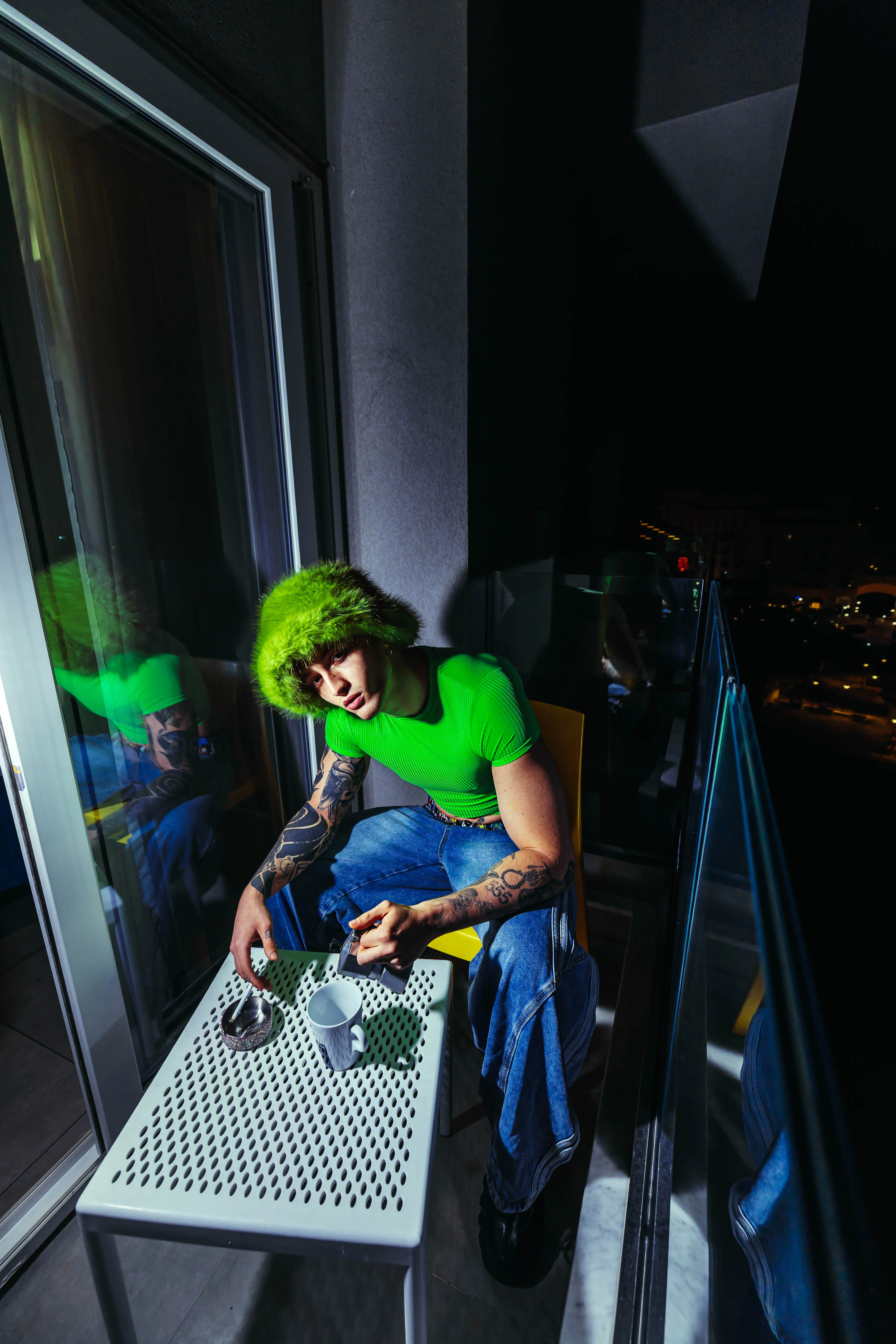 Guest enjoying coffee on the balcony with night city views