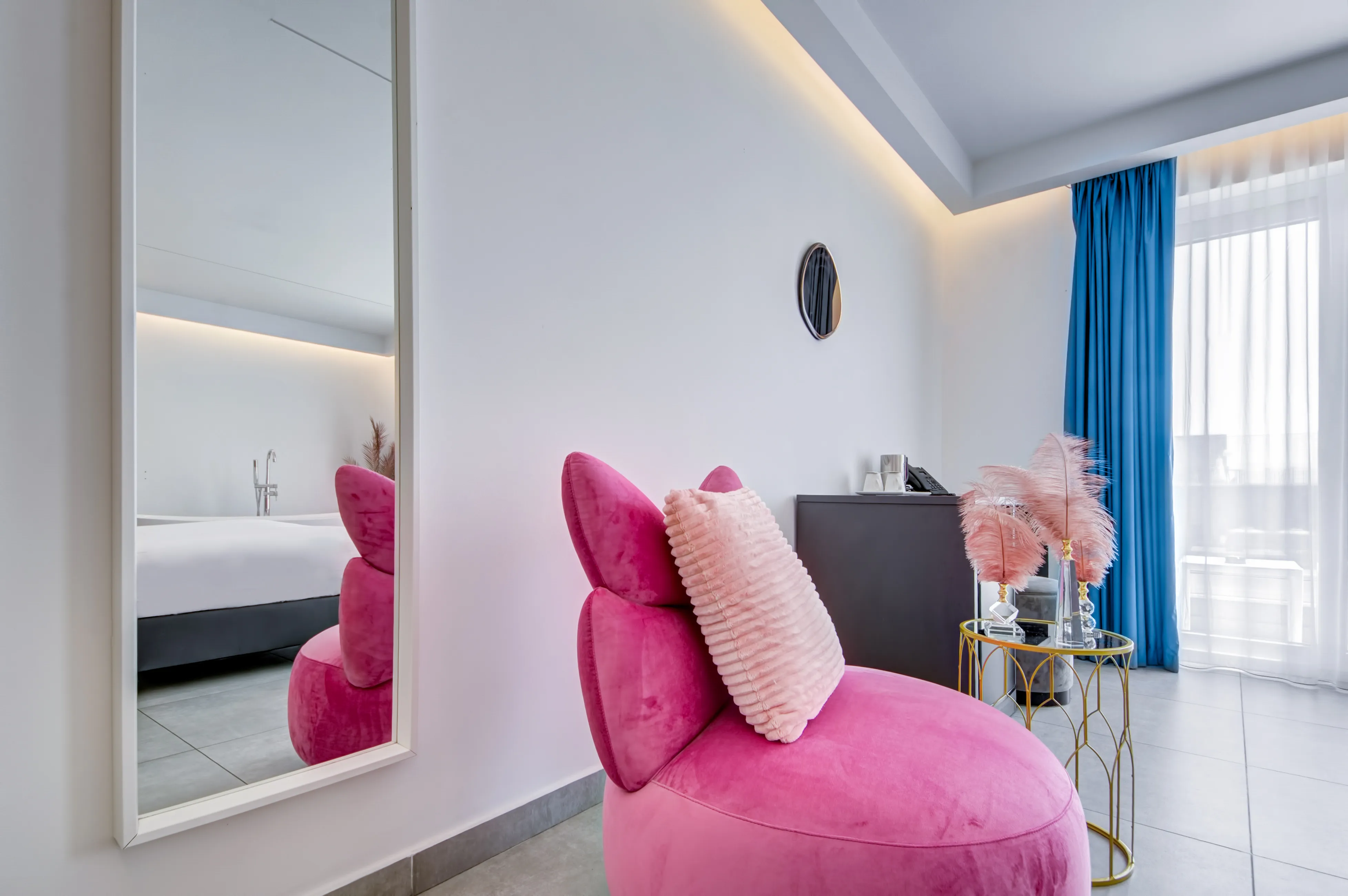 Pink velvet chair with mirror reflecting suite